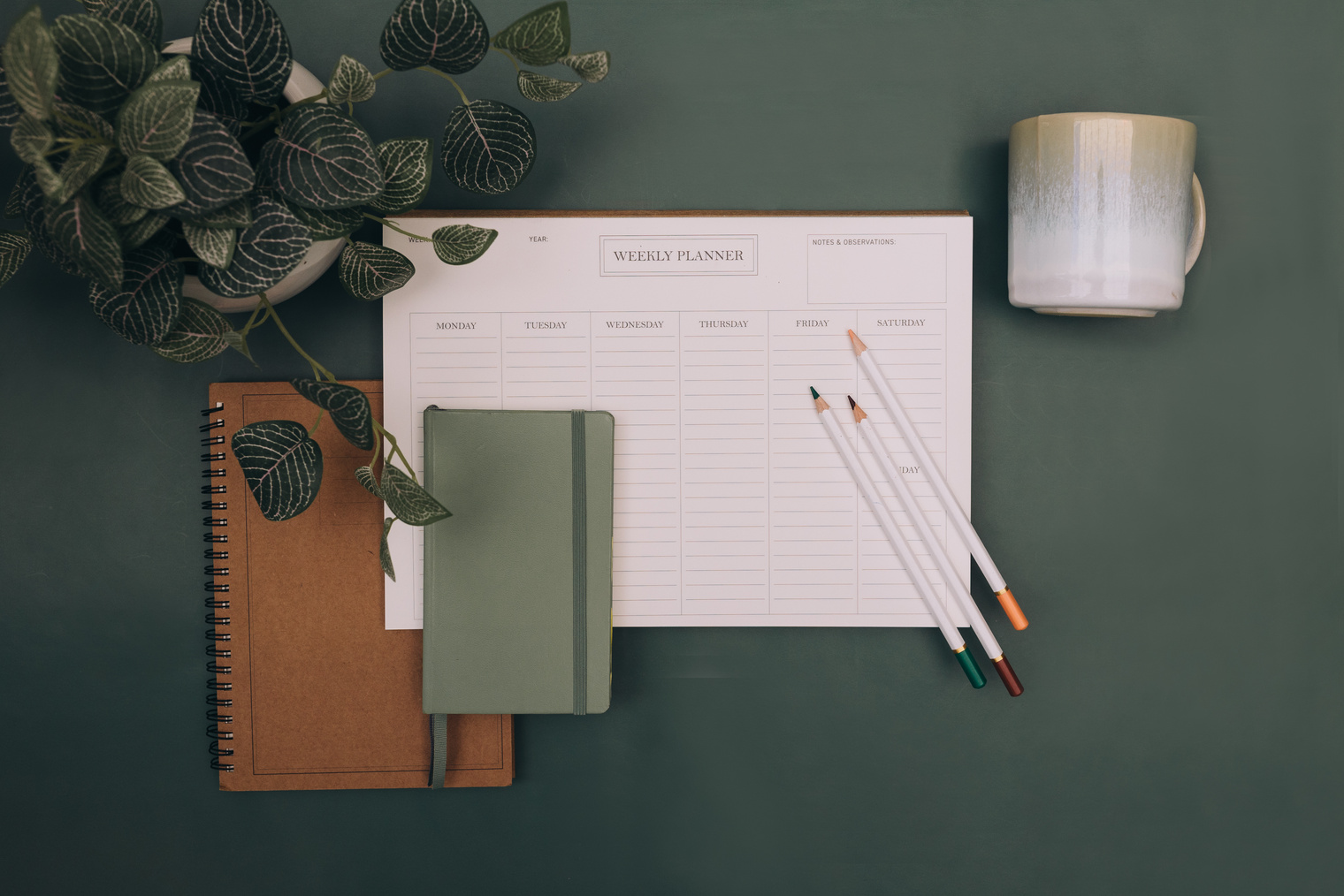 Notebooks, Calendar, Mug and Pencils on Green Background